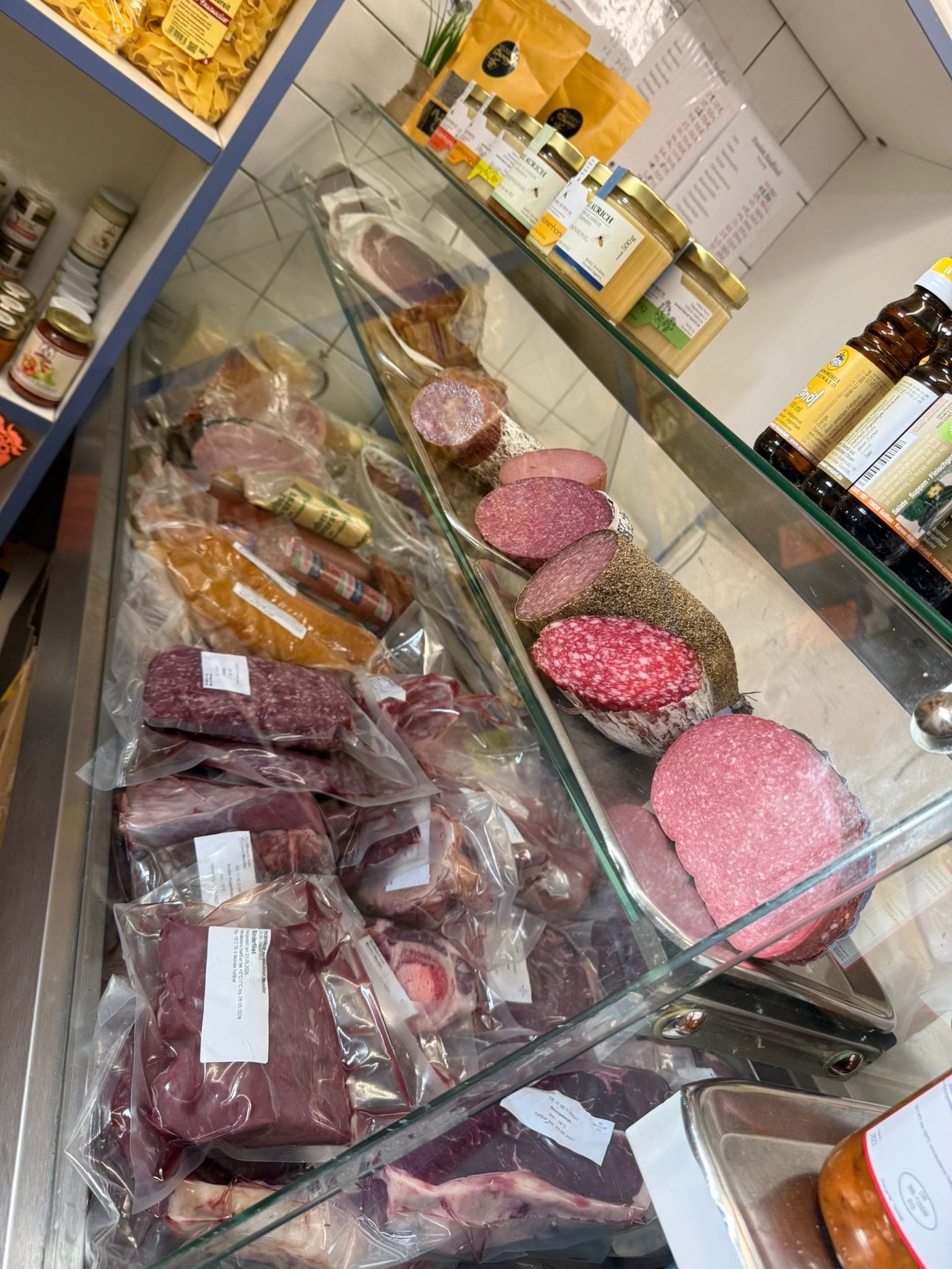 Theke mit Wurst, Salami und Honig im Hofladen